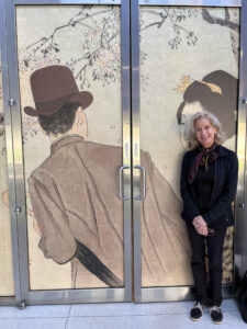 Victoria Melendez at the entrance to JASA’s “Meiji Modern” exhibition at the Smart Museum of Art, University of Chicago, with a JASA group attending the symposium. May 3, 2024. Photo: Amy Poster